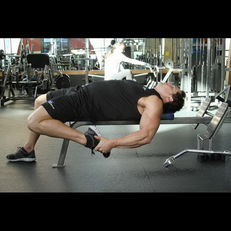 техника выполнения упражнения: Растяжка мышц бедра лежа на скамье (On-Your-Back Quad Stretch) на фото